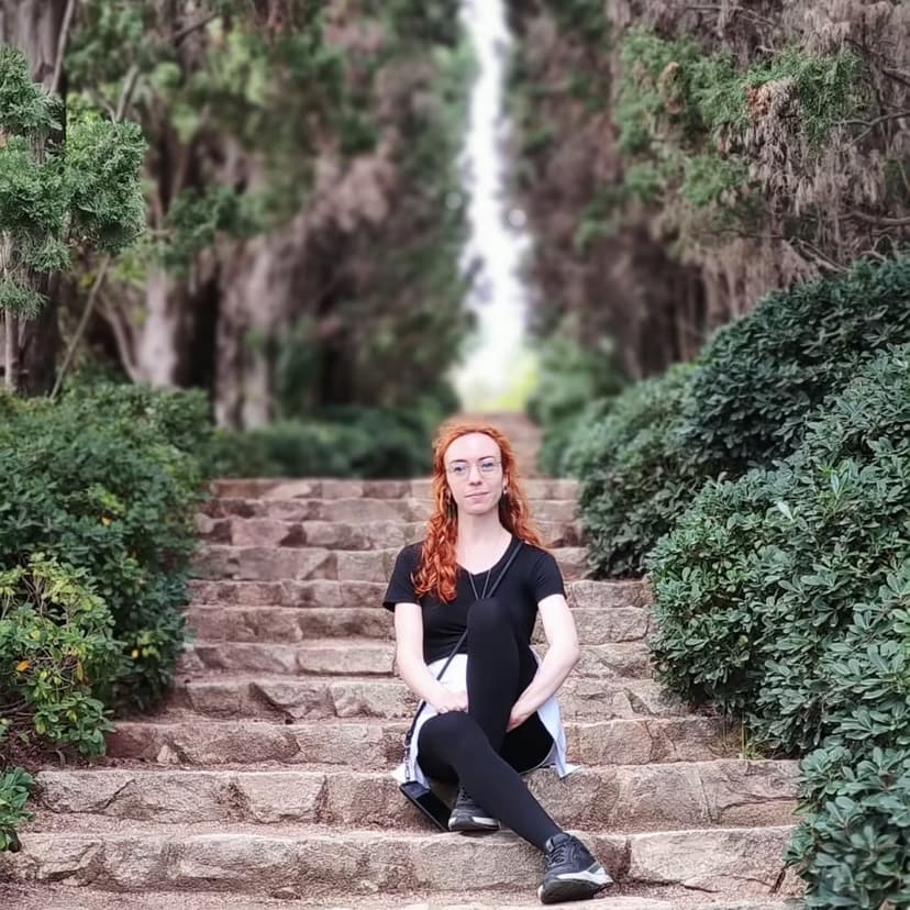 Woman sitting on the stairs, surrounded by trees.