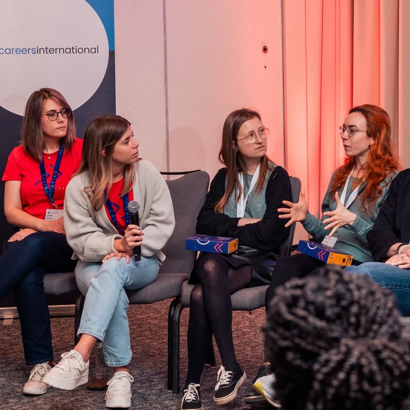 A group of women, sitting, talking in a conference room